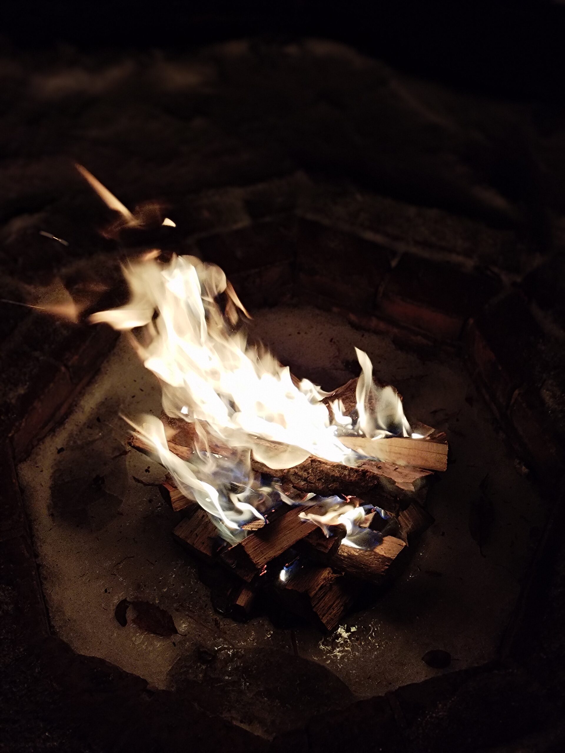 夜の焚き火。暗闇の中で炎が揺れる