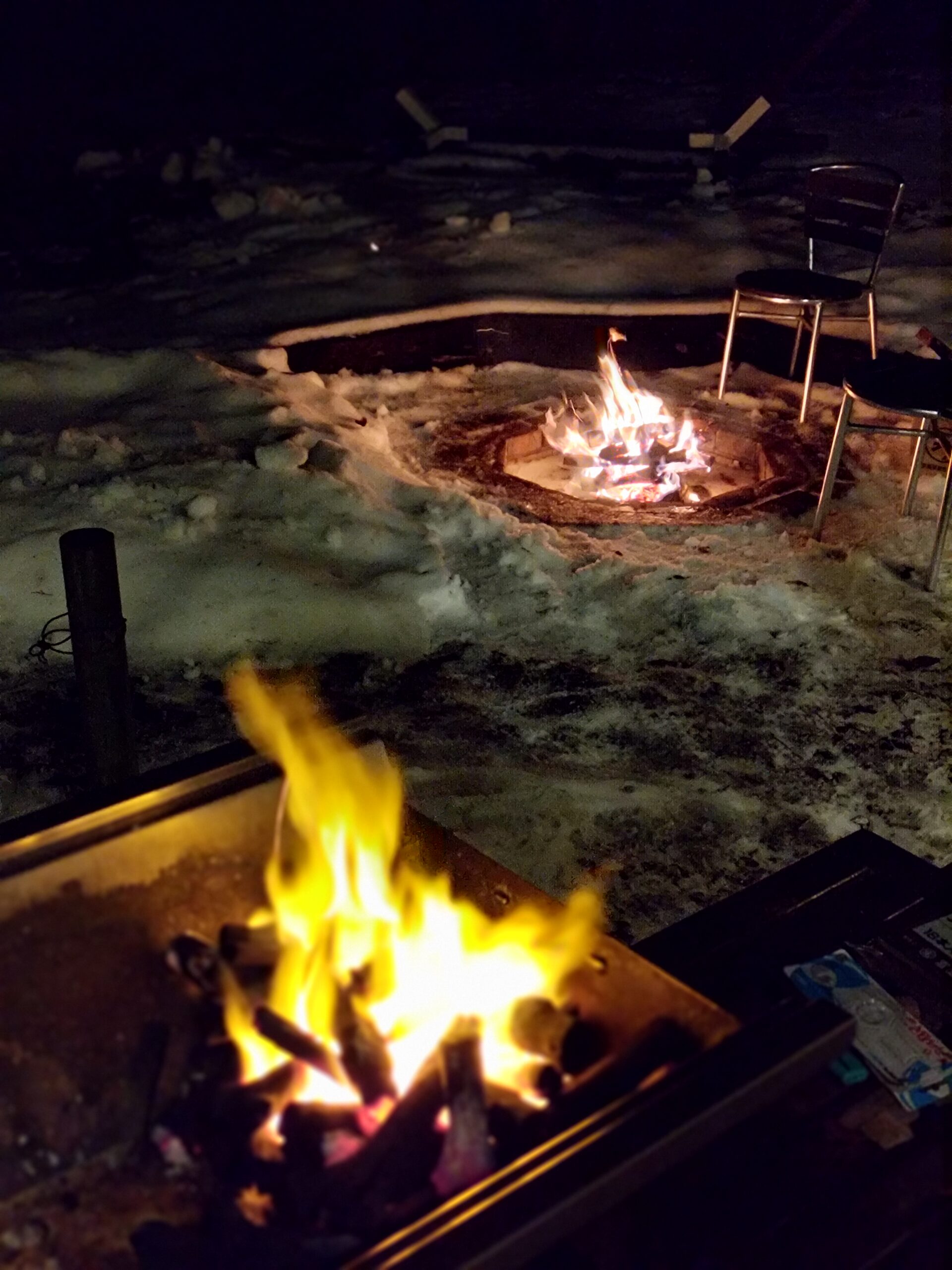 夜のBBQ。焚き火台と炭火グリルが並ぶ、雪の中